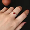 Handmade freshwater pearl ring featuring a red agate bead worn on a female finger. - Handmade Woven Freshwater Pearl Ring with Red Agate