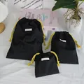 Detailed view of three black Oxford cloth drawstring storage bags for travel use - Three-Piece Set / Black