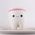 Nahaufnahme eines süßen lächelnden Zahn-Squishy-Spielzeugs zum Stressabbau. - 11cm*8cm*7cm / Rosa
