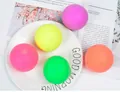 Détail de quatre balles anti-stress arc-en-ciel disposées sur une assiette blanche - Balle de Couleur Unie 7cm (Aléatoire)