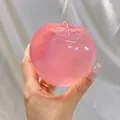 Detailed view of a semi-transparent pink jelly apple stress relief squishy toy held in hand - Pink Apple Shape / 6x7cm Size