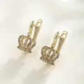Detailed macro view of gold-plated crown earrings with shimmering cubic zirconia stones. - 14K Gold