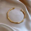 Elegante bracciale rigido in acciaio inossidabile dorato con design a bambù - Forma a Nodo di Bamboo - Oro (s402jin)