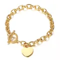 Gros plan d'un bracelet en acier inoxydable doré avec fermoir en T et pendentif cœur. - Bracelet Doré (DZG151)