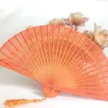 Elegantly carved orange wooden folding fan featuring intricate hollow patterns and a silky tassel - Hollow Wood Fan (With Tassel) / Yellow