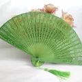 Elegant green hollowed-out wooden folding fan with intricate carved patterns and tassel - Hollow Wood Fan (With Tassel) / Green