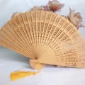 Elegant hollow carved wooden folding fan with yellow tassel for weddings and dance. - Gold
