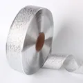 Détail en gros plan montrant la texture pailletée argentée du ruban métallique de 100 yards. - Taille 100 / Argenté