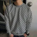 Close-up of men's grey and white checkerboard knit sweater featuring a ribbed crew neck line - S / Tops / Gray
