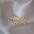 Dettaglio di eleganti anelli regolabili in oro con farfalla e fiori in zircone viola - Aperto Regolabile / Fiore Viola Farfalla Bianca (JZ003)