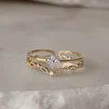 Vista dettagliata di un elegante anello regolabile in oro con pietre azzurre chiare - Aperto Regolabile / Fiore Blu Chiaro Design Traforato (JZ004)