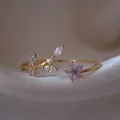 Elegante anello regolabile placcato oro con fiori di zircone viola e accenti di foglie. - Aperto Regolabile / Design Vite Fiore Viola (JZ026)