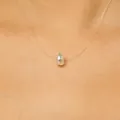 Close-up of invisible fishing line necklace with faceted teardrop crystal pendant - White