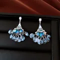Close-up of vintage fan-shaped earrings with sparkling blue crystals and tassels. - Fan Tassel Style (HE34448) / Blue
