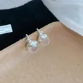 Vista dettagliata di ciondoli a forma di ghianda in argento con zirconi sfaccettati - Orecchini / Argento-Bianco