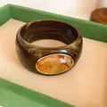 Close-up of vintage wide acrylic bangle with marbled pattern and oval amber detail - Vintage Wide Style (HB6269) / Brown-Coffee
