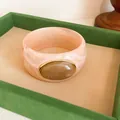 Close-up detail of retro pink marbled acrylic bangle with an elegant oval stone inlay - Vintage Wide Style (HB6269) / Pink & Light Brown