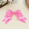 Close-up of a pink Lolita-style satin ribbon bow hair clip featuring mini bow accents - Rose Red