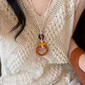 Artistic wood geometric hollow rings necklace shown on a beige crochet knit top - Bamboo Texture Circle Style (45#)