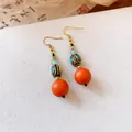 Detailed view of ethnic style retro earrings with red resin beads and gold hooks. - Ear Hook - Gold - Brown