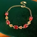 Vista dettagliata del bracciale placcato oro 18k con zirconi rossi ovali e fiori. - Stile Fiore Zirconia Ovale Rosso / Oro