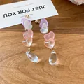 Detailaufnahme der lichtdurchlässigen Herz- und Tropfenperlen an eleganten Hängeohrringen - 原木桌面甜美半透心形款(79#) / Gold Rosa Violett Transtransparent