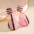 Close-up of pink and purple resin teardrop earrings with artistic ink wash marbled pattern - Pink
