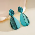 Detailed view of blue marbled resin teardrop earrings with artistic ink pattern - Stud Pin Style / Blue