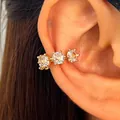 Macro shot of a luxury gold-tone ear cuff featuring three sparkling cubic zirconia. - Gold (X180)