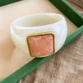 Close-up of a wide ivory acrylic bangle with a square pink marbled centerpiece - Ivory Base Pink Square / Ivory White-Pink