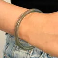 Vista detallada de una pulsera de resina verde traslúcida en una muñeca femenina - Brazalete de Círculo Delgado (7031) / Gris