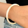 Detalle de una fina pulsera de resina tipo jade en blanco y caramelo puesta en la muñeca. - Brazalete de Círculo Delgado (7772) / Blanco
