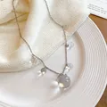 Detalle de cerca de un collar de estilo coreano con esferas de resina traslúcida en cadena plateada - Collar / 1 Pieza / Blanco
