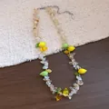 Vista dettagliata di una collana di perline in resina con ciondoli a forma di limone. - Collana con Perline Chips di Resina Limone Argento / Giallo