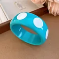 Detailed view of a bright blue resin bangle featuring bold white polka dots design - Chunky Hoop / Blue Polka Dot