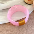 Bracelet en résine rose marbrée avec détails de fil doré élégants sur fond texturé - Or-Rose Clair