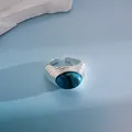Detalle de anillo ajustable vintage con textura plisada y piedra azulada - Estilo con piedra azul texturizada / Plateado