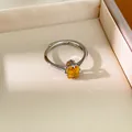 Gros plan d'une élégante bague en argent ornée d'un zircon jaune ovale facetté - Jaune