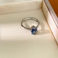 Gros plan d'une bague ajustable argentée avec pierre précieuse ovale bleue. - Bleu tanzanite