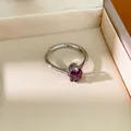 Gros plan d'une bague en argent avec zircon violet dans un écrin à bijoux beige - Violet
