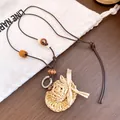 Detail van gevlochten strooien hoed hanger met houten kralen aan bruin leren koord - Mini Strohoed Hanger / Koffie/Wit