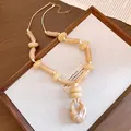 Macro detail showing cream marble acrylic beads and leather cord of this beach style necklace - Beige