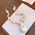 Detailed view of beige marble-patterned acrylic beads and a hollow oval pendant necklace. - Irregular Style / Beige