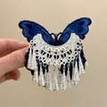 Macro detail of a vintage blue embroidered butterfly hair clip featuring silver tassels - Single Piece / Silver-Blue