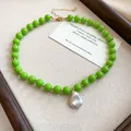 Detailed macro view of vibrant green acrylic bead necklace with a baroque pearl pendant - Green