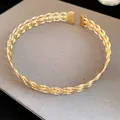 Detailansicht eines goldfarbenen, geflochtenen Metall-Halsreif-Halsketten-Designs. - Gekreuztes Halsband / Gold