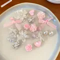 Assorted resin shoe charms featuring pink flowers, bows, and silver butterflies on a plate. - 12-Piece Set / White/Pink