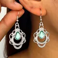 Gedetailleerde close-up van boheemse zilveren holle oorbellen met turquoise stenen - Wit (H-233)