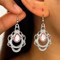 Gedetailleerde close-up van zilveren vintage bohemien oorbellen met roze druppelstenen - Wit (1081)