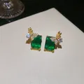 Détail macro de boucles d'oreilles carrées vert émeraude plaquées or 18 carats avec papillon - Boucles d'Oreilles Uniquement / Or-Vert